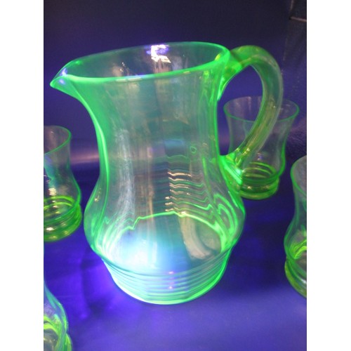 300 - A 1930s uranium glass lemonade set, 4 glasses and a jug, two glasses with small chips to edge