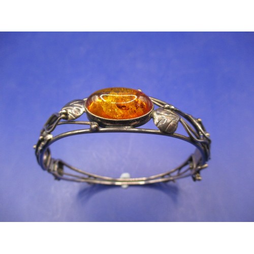 77 - A vintage silver bangle, having organic form with cabochon amber panel, in good pre-owned condition ... 