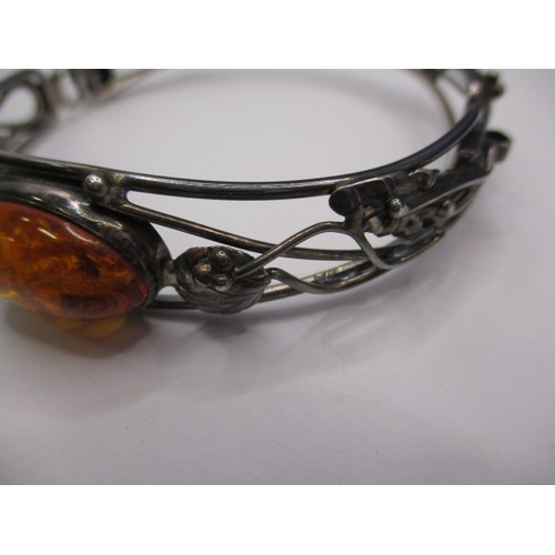 77 - A vintage silver bangle, having organic form with cabochon amber panel, in good pre-owned condition ... 