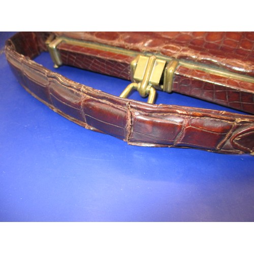 189 - An early 20th Century Crocodile skin handbag. Clasp works well, with age related ware and a split to... 