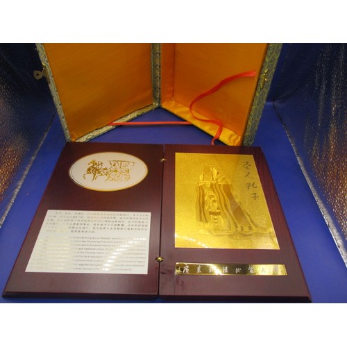 174 - A boxed, wood covered booklet on with a story of Confucius having gold panel marked 999.9, in use co... 