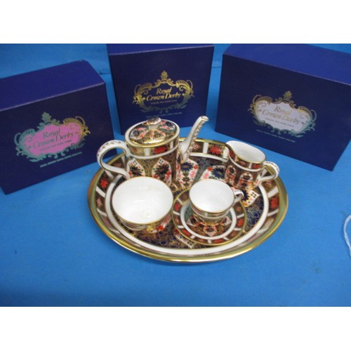 182 - A Royal Crown Derby miniature tea set on tray, in the 1128 pattern, all with same date numbers, in u... 