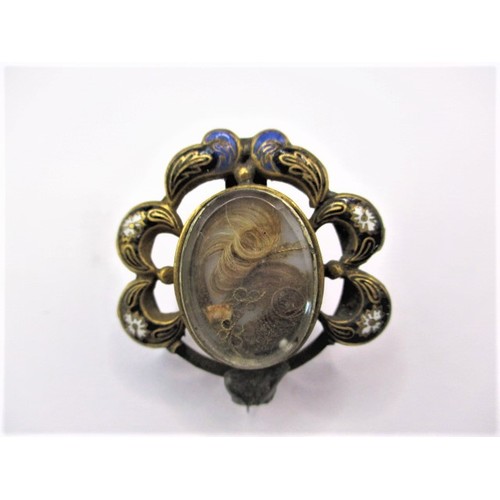 83 - A 19th century mourning brooch with hair panel and enamel decoration, some trim missing to edge