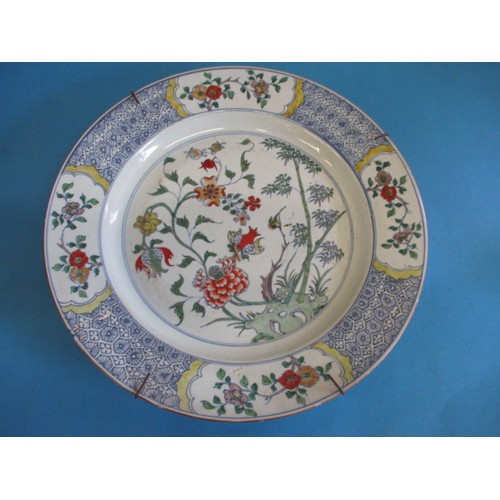 173 - An antique oriental wall plate with polychrome floral decoration front and back, approx. diameter 36... 