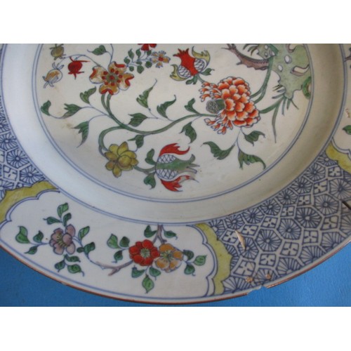 173 - An antique oriental wall plate with polychrome floral decoration front and back, approx. diameter 36... 