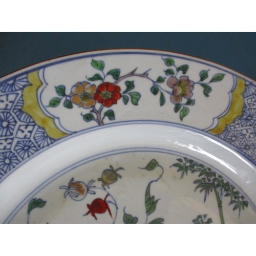 173 - An antique oriental wall plate with polychrome floral decoration front and back, approx. diameter 36... 