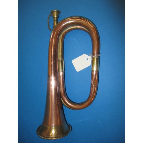 224 - A copper and brass bugle. With age related wear and some minor denting