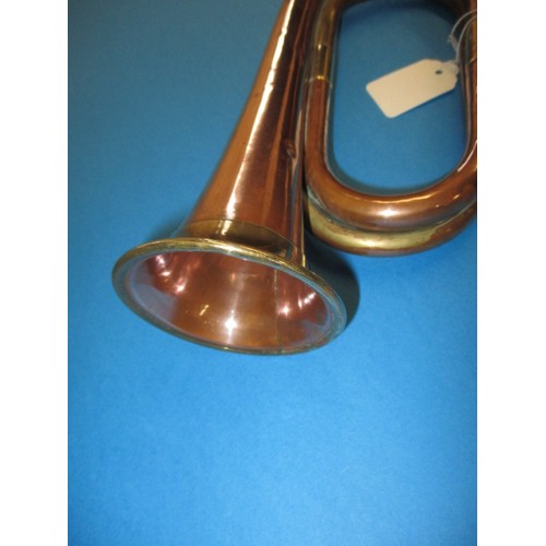 224 - A copper and brass bugle. With age related wear and some minor denting