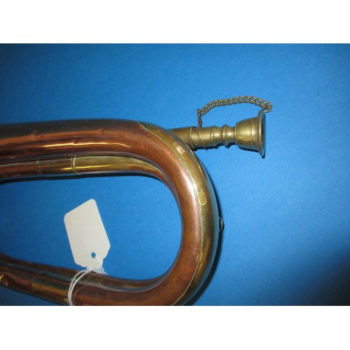 224 - A copper and brass bugle. With age related wear and some minor denting