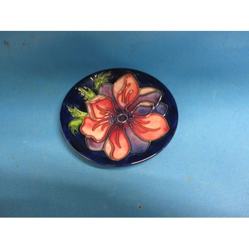 180 - A Moorcroft pin dish in Anemone pattern. Approximate diameter 10.5cm . In good condition with no vis... 