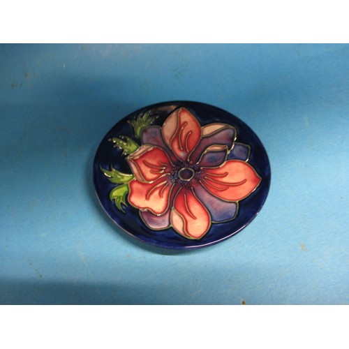 180 - A Moorcroft pin dish in Anemone pattern. Approximate diameter 10.5cm . In good condition with no vis... 