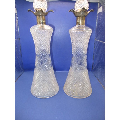 A pair of antique silver mounted drinks decanters, hallmarked Sheffield 1910/11, one with a chipped stopper, approx. height 33cm