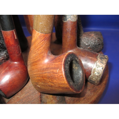 134 - A vintage pipe rack and pipes, to include a silver collared example, some damages and all in used co... 