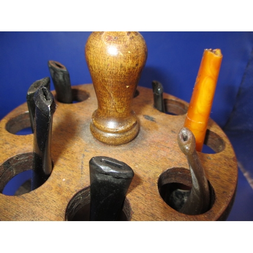 134 - A vintage pipe rack and pipes, to include a silver collared example, some damages and all in used co... 