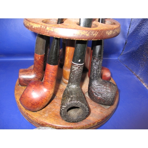 134 - A vintage pipe rack and pipes, to include a silver collared example, some damages and all in used co... 