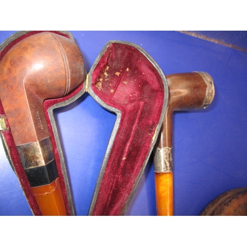 134 - A vintage pipe rack and pipes, to include a silver collared example, some damages and all in used co... 