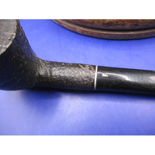 134 - A vintage pipe rack and pipes, to include a silver collared example, some damages and all in used co... 