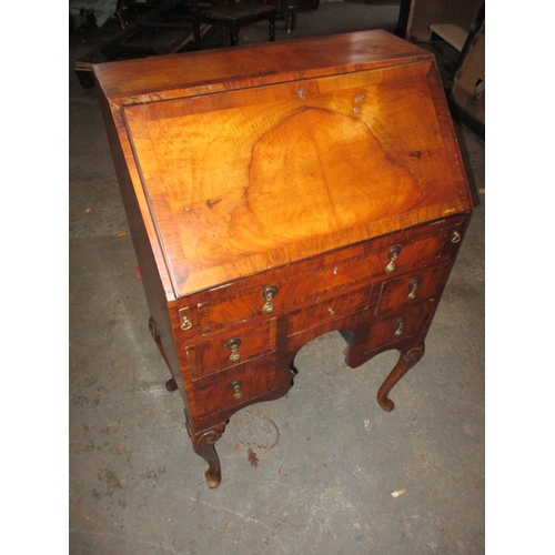 303 - A vintage writing bureau with compartmented interior over an array of drawers, having use-related ma... 