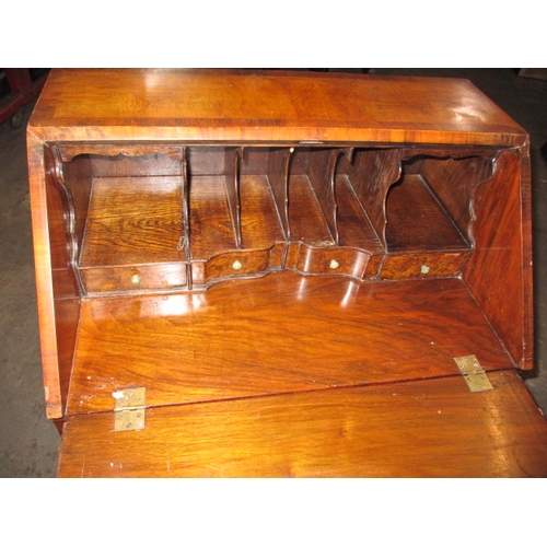 303 - A vintage writing bureau with compartmented interior over an array of drawers, having use-related ma... 