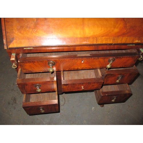 303 - A vintage writing bureau with compartmented interior over an array of drawers, having use-related ma... 