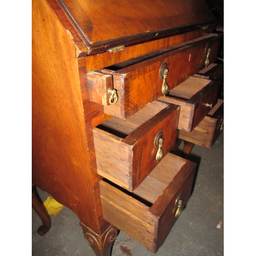 303 - A vintage writing bureau with compartmented interior over an array of drawers, having use-related ma... 