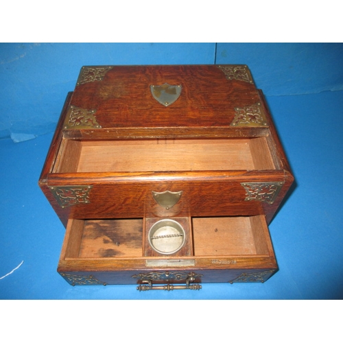 285 - An early 20th century oak desk top stationary box, the top opening is operated via the base drawer, ... 