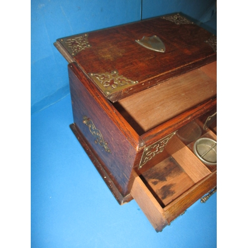 285 - An early 20th century oak desk top stationary box, the top opening is operated via the base drawer, ... 