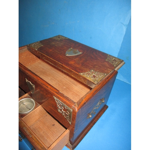 285 - An early 20th century oak desk top stationary box, the top opening is operated via the base drawer, ... 