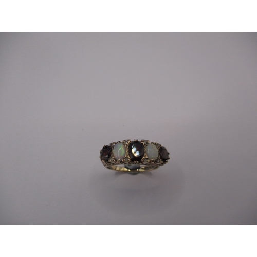 11 - A vintage 9ct gold ring set with diamonds garnets and opals. Approx. ring size ‘R’, approx. weight 5... 