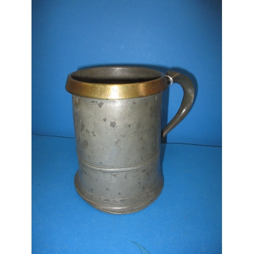 66 - A 19th century quart pewter tankard with brass rim, having numerous official measure stamps, some de... 