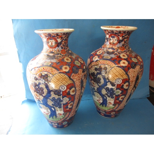 75 - A large pair of vintage Imari vases, approx. height 47cm with hand painted decoration, one having re... 