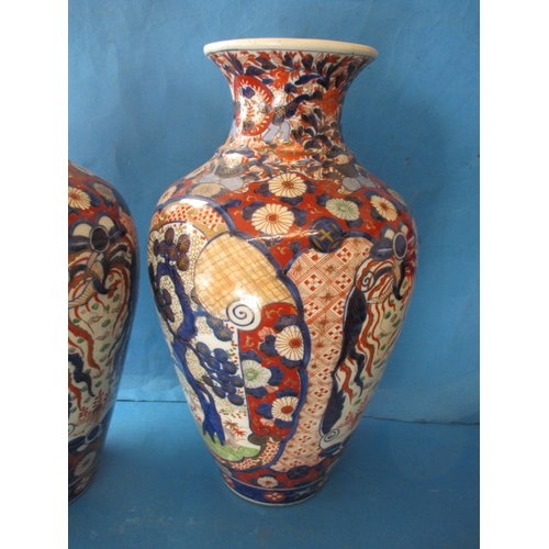 75 - A large pair of vintage Imari vases, approx. height 47cm with hand painted decoration, one having re... 