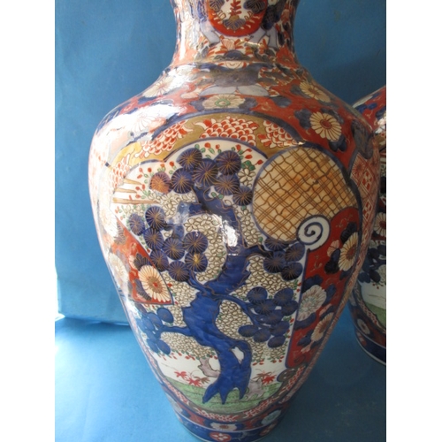 75 - A large pair of vintage Imari vases, approx. height 47cm with hand painted decoration, one having re... 