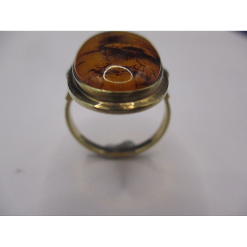 17 - A 1930s gold ring with a single oval cabochon amber panel, marked 333, approx. ring size ‘O’, approx... 