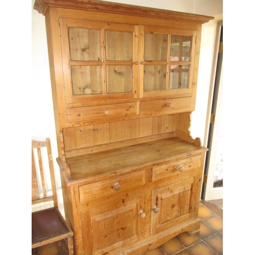 317 - A vintage natural pine kitchen dresser with glazed top rack with drawers and cupboards to base, in g... 