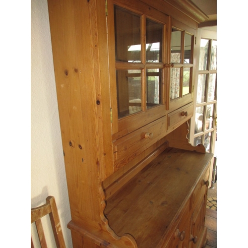 317 - A vintage natural pine kitchen dresser with glazed top rack with drawers and cupboards to base, in g... 