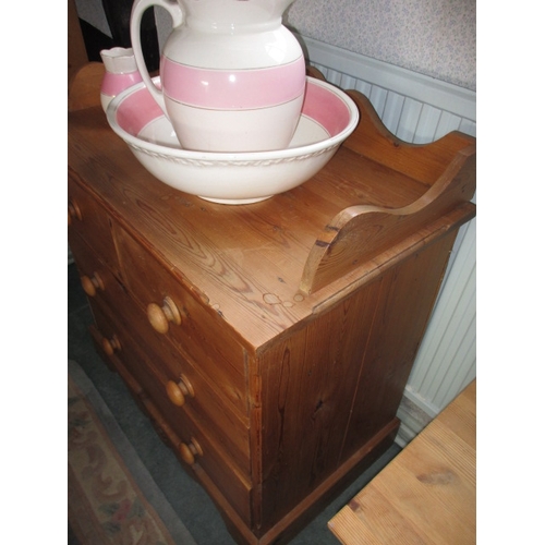 309 - A vintage pine wash stand with 2 short over 2 long drawers and an associated jug and bowl, in functi... 