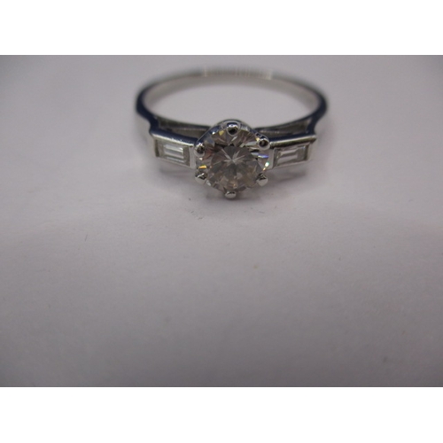 11 - A 1930s Art Deco platinum and diamond ring, with central diamond of approx. 0.65ct flanked by emeral... 