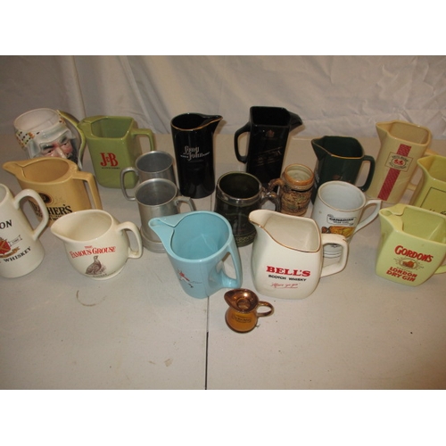 64 - A collection of pub water jugs, with examples by Wade. In used condition, one with a chip to top rim