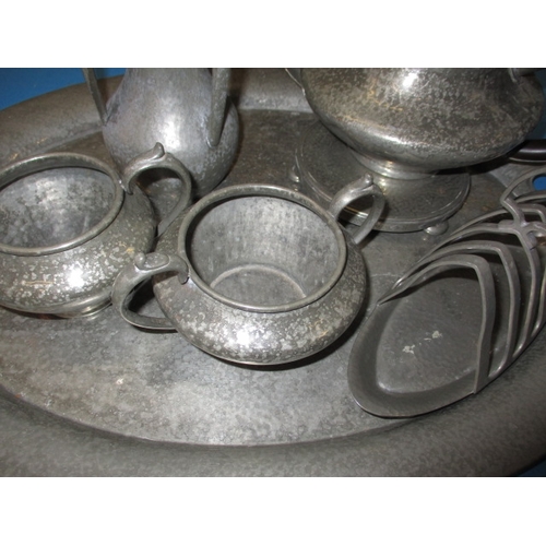 172 - A quantity of early 20th century hand hammered pewter items, to include a large tray, all in used co... 