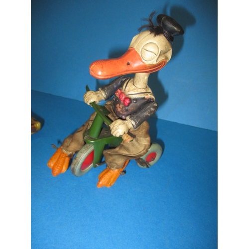 209 - A vintage clockwork cycling duck, a tank and a celluloid hanging mobile, all in play worn condition,... 