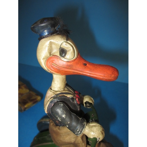 209 - A vintage clockwork cycling duck, a tank and a celluloid hanging mobile, all in play worn condition,... 