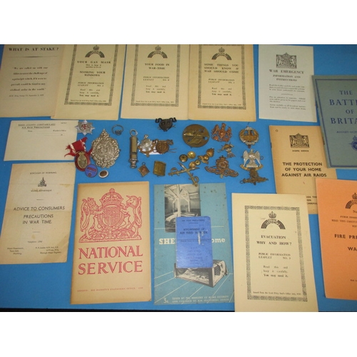 216 - A parcel of WWII military related items, to include metal badges and Civil defence public informatio... 