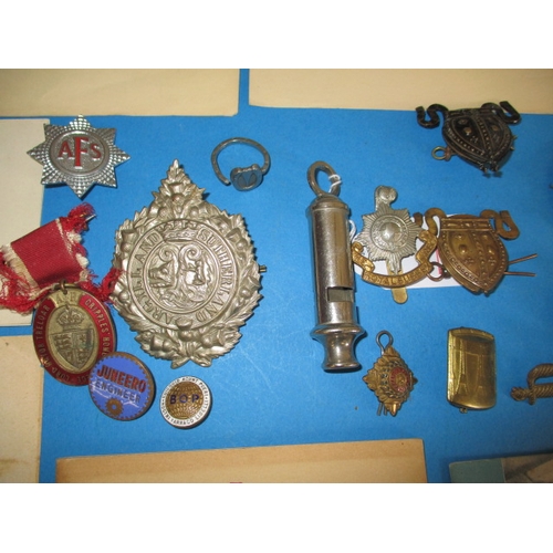 216 - A parcel of WWII military related items, to include metal badges and Civil defence public informatio... 