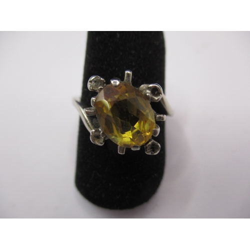 20 - An unmarked white gold ring, tested as 9ct with large central yellow stone, electronic test indicate... 