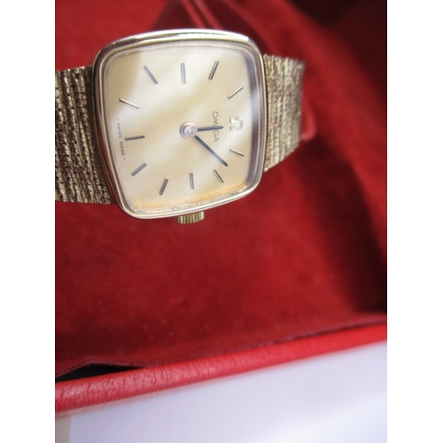 113 - A vintage 9ct gold omega watch, having 9ct gold integral strap, in current working order with a box ... 