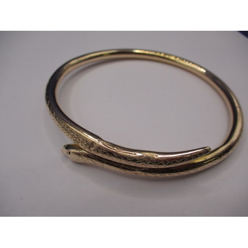 62 - A vintage yellow gold forearm bangle in the shape of a coiled snake, approx. weight 13.45g, having s... 