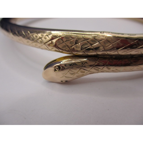 62 - A vintage yellow gold forearm bangle in the shape of a coiled snake, approx. weight 13.45g, having s... 