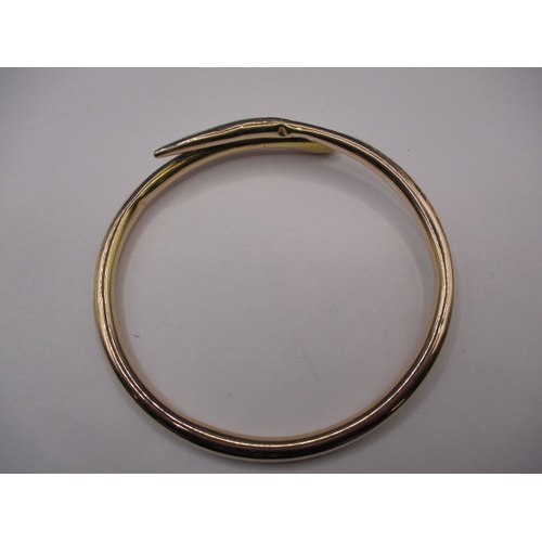 62 - A vintage yellow gold forearm bangle in the shape of a coiled snake, approx. weight 13.45g, having s... 