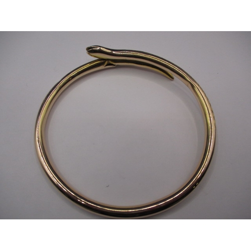 62 - A vintage yellow gold forearm bangle in the shape of a coiled snake, approx. weight 13.45g, having s... 